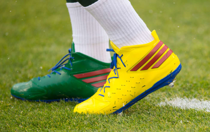 View of Aaron Rodgers' green and yellow Adidas cleats.